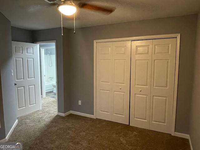 unfurnished bedroom featuring ceiling fan, a closet, and dark carpet