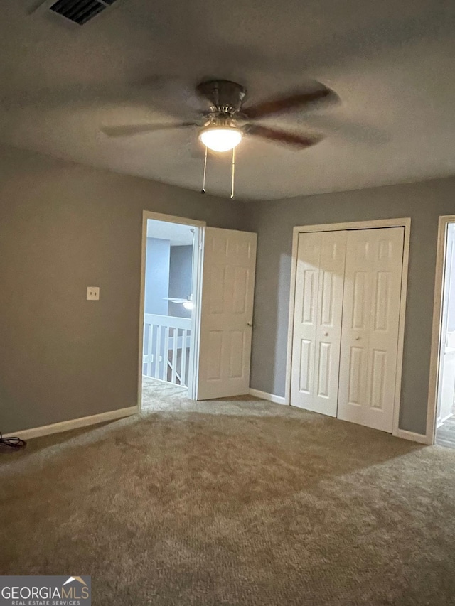 unfurnished bedroom featuring ceiling fan, a closet, and carpet floors