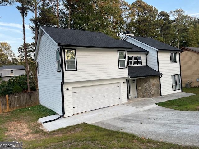 view of front of home featuring a garage and central AC