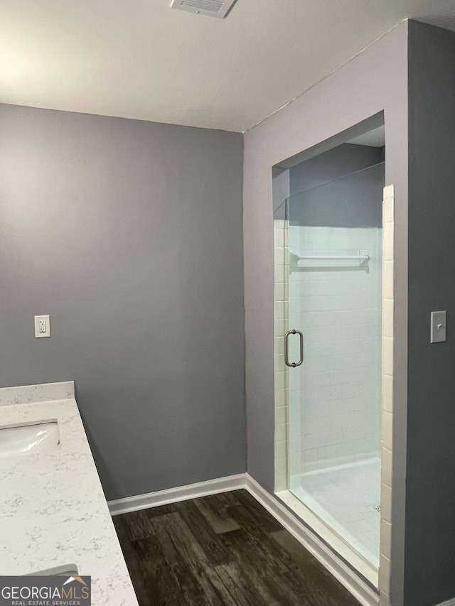 bathroom featuring wood-type flooring, vanity, and walk in shower