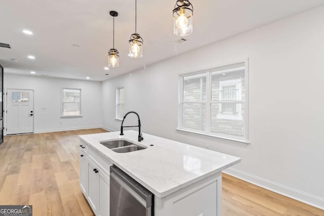 kitchen with pendant lighting, a kitchen island with sink, white cabinets, sink, and stainless steel dishwasher