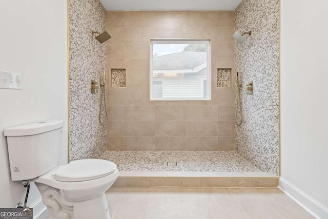 bathroom with a tile shower, tile patterned flooring, and toilet