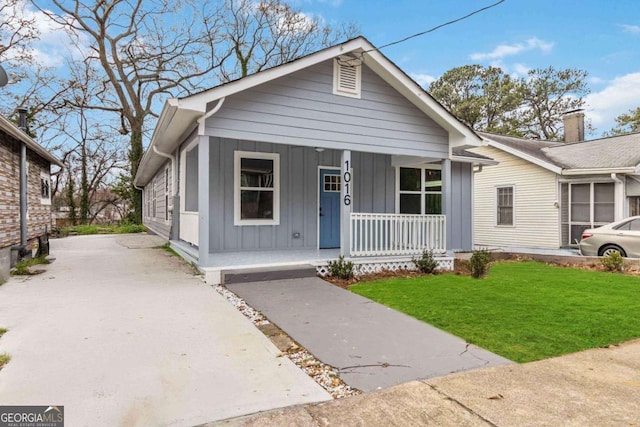 view of front of house with covered porch and a front lawn