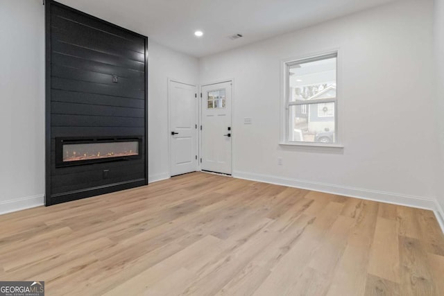 foyer with a fireplace and light hardwood / wood-style flooring