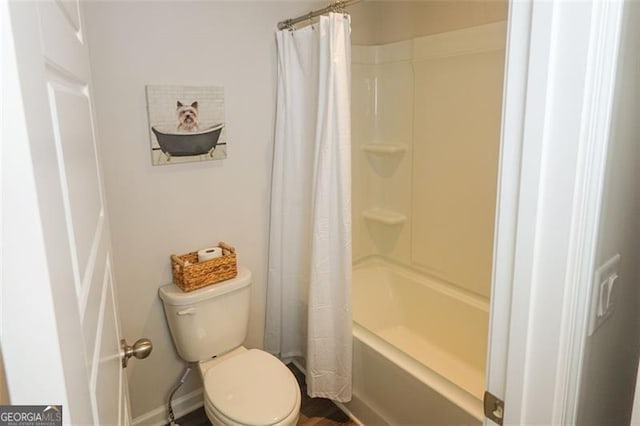 bathroom featuring shower / tub combo and toilet