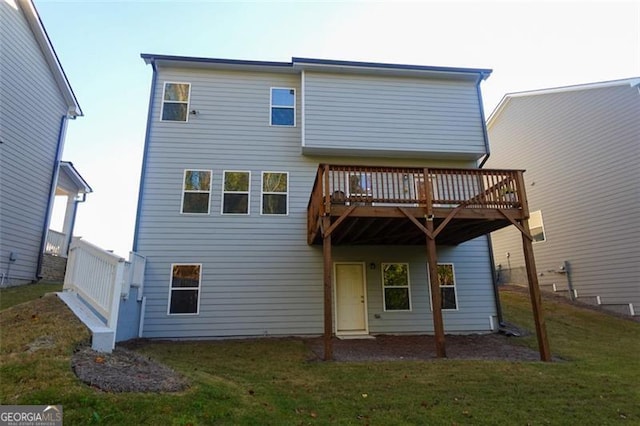 rear view of property with a yard and a wooden deck