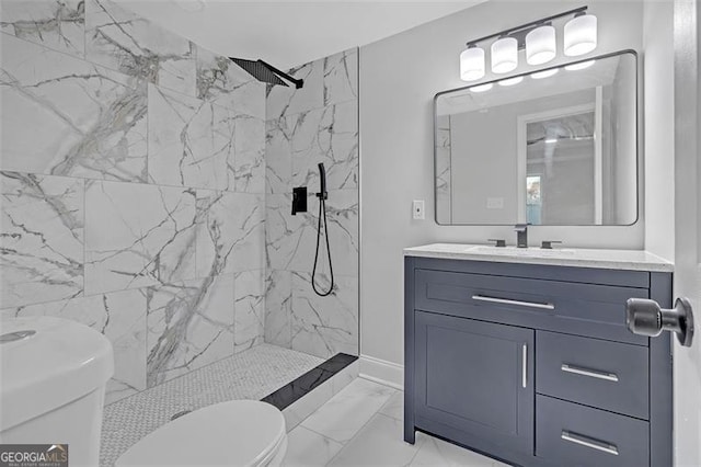 bathroom featuring tiled shower, vanity, and toilet