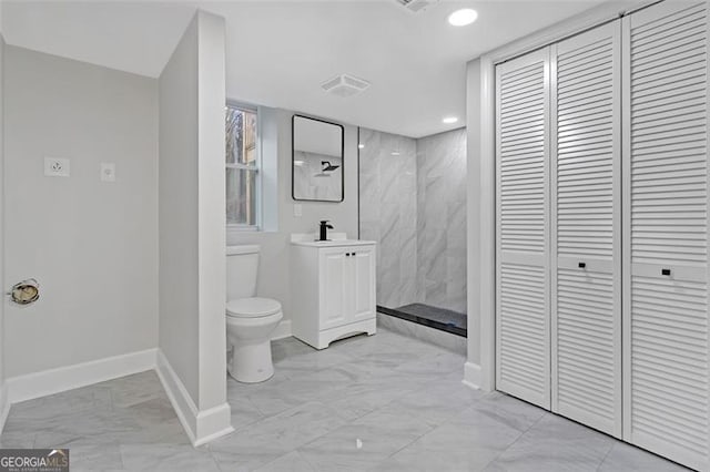 bathroom featuring vanity, toilet, and tiled shower