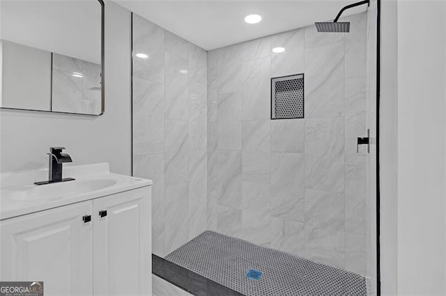 bathroom with vanity and tiled shower