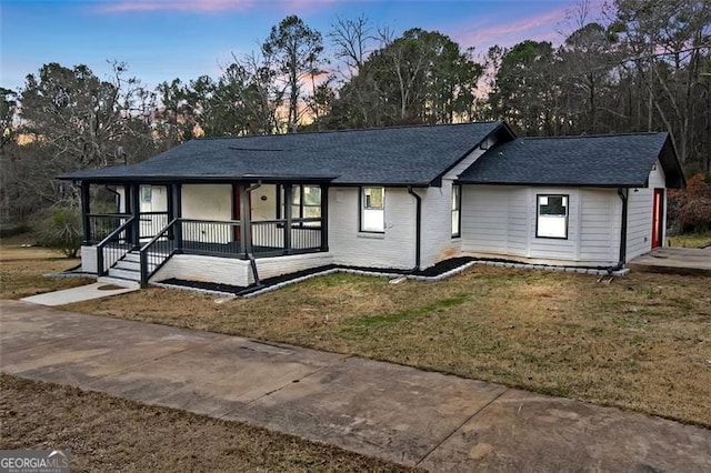 ranch-style house featuring a lawn and a porch