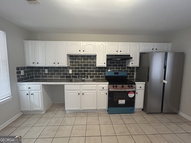 kitchen with stainless steel fridge, stove, white cabinetry, and sink