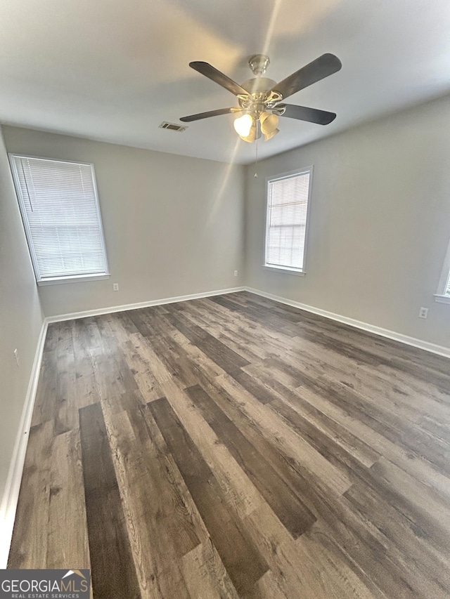 spare room with dark hardwood / wood-style flooring and ceiling fan