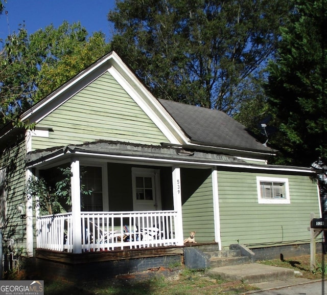 rear view of house featuring covered porch