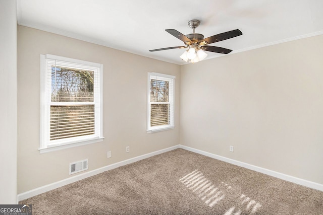 empty room featuring carpet flooring, ceiling fan, and ornamental molding