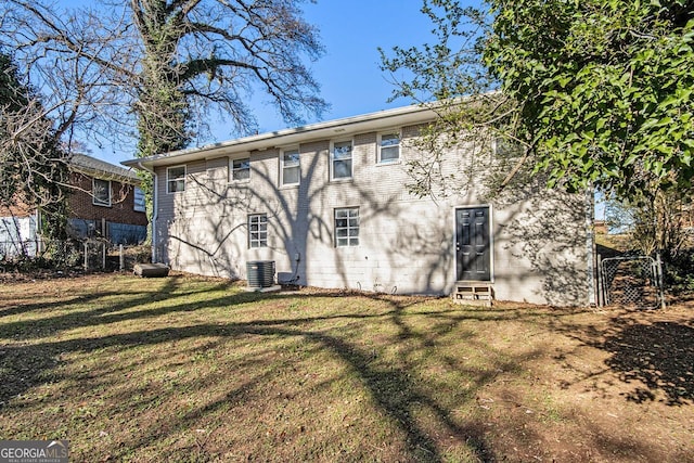 rear view of property with a lawn and central AC