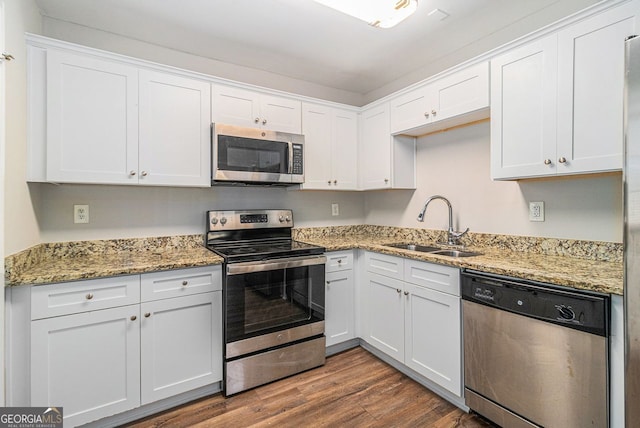 kitchen featuring wood-type flooring, sink, white cabinetry, and stainless steel appliances