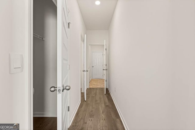 corridor with hardwood / wood-style flooring