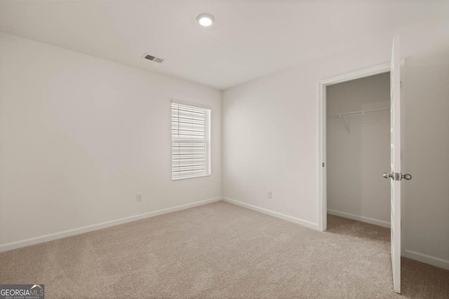 unfurnished bedroom with a closet and light colored carpet