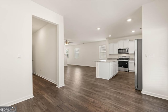 kitchen featuring stainless steel appliances, ceiling fan, white cabinets, dark hardwood / wood-style floors, and a kitchen island