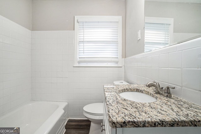 bathroom with vanity, wood-type flooring, tile walls, toilet, and a tub