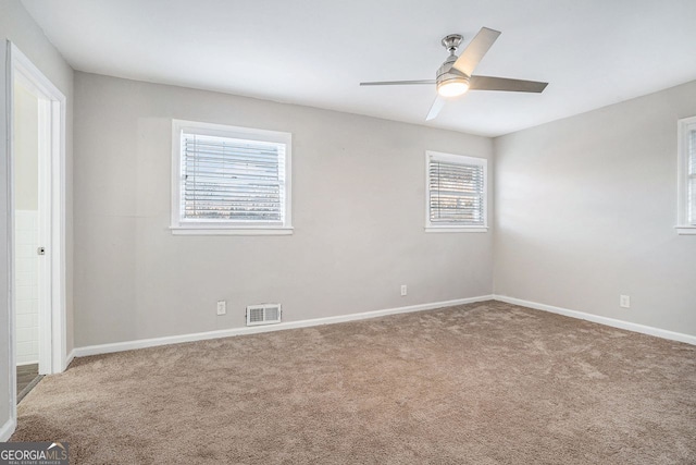 empty room featuring carpet, ceiling fan, and a healthy amount of sunlight