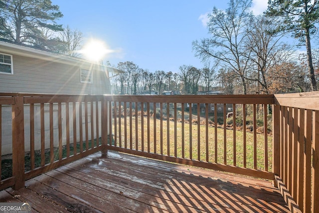 wooden terrace featuring a lawn