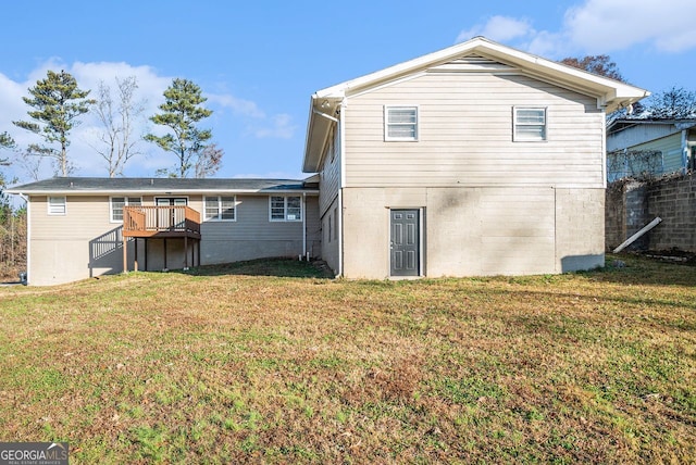 rear view of house featuring a lawn and a deck