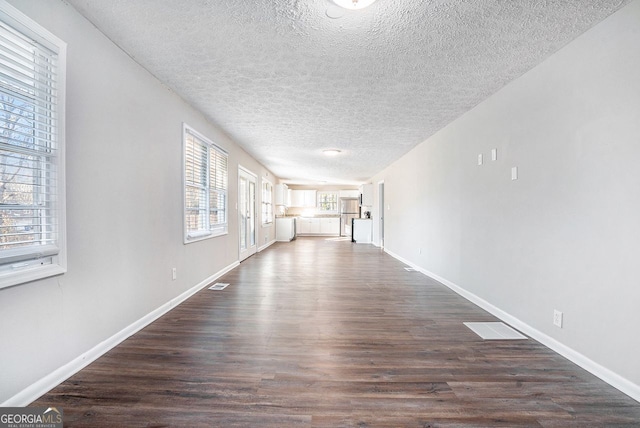 hallway featuring a textured ceiling and dark wood-type flooring