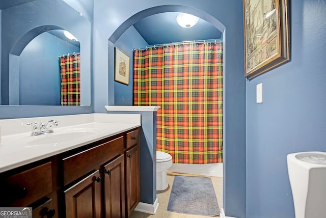 bathroom with tile patterned flooring, vanity, toilet, and curtained shower