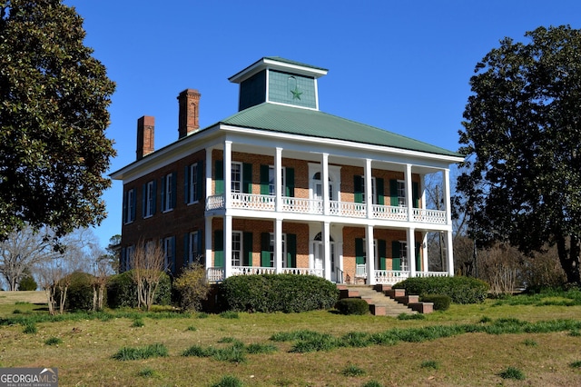 greek revival inspired property featuring a front yard and a porch