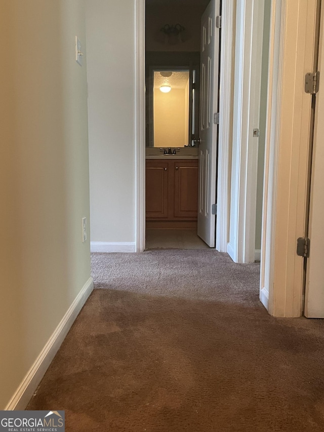 hallway featuring carpet flooring and sink