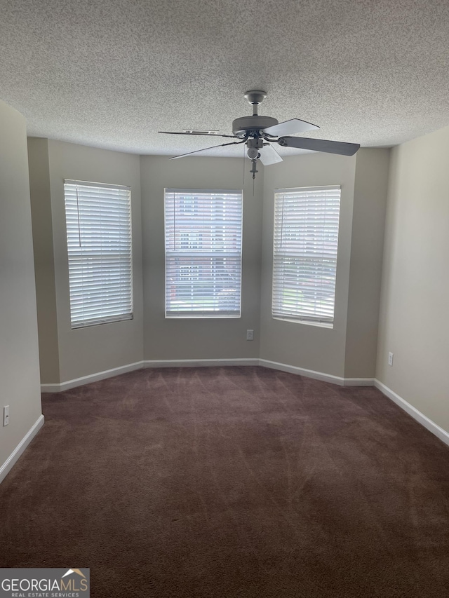 carpeted empty room featuring ceiling fan and a textured ceiling