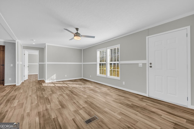 unfurnished living room with ceiling fan, light hardwood / wood-style flooring, a textured ceiling, and ornamental molding