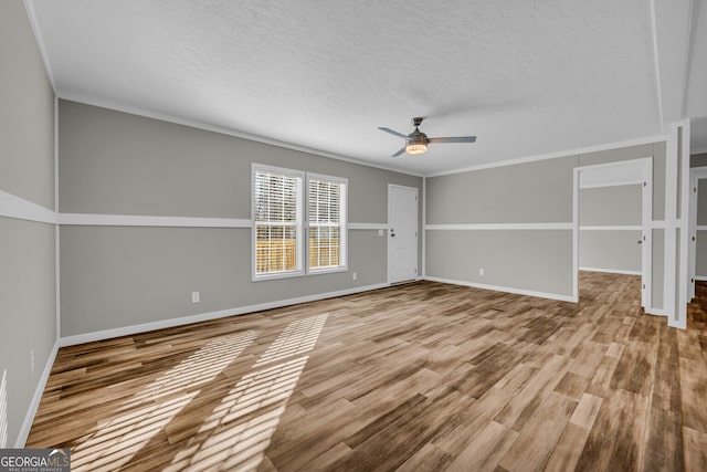 unfurnished room featuring ceiling fan, light wood-type flooring, and crown molding