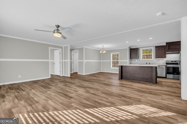 unfurnished living room featuring ceiling fan with notable chandelier, light hardwood / wood-style floors, ornamental molding, and sink