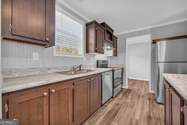 kitchen with appliances with stainless steel finishes, light hardwood / wood-style flooring, ornamental molding, and sink