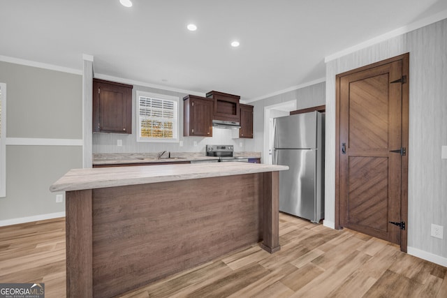 kitchen with dark brown cabinets, a center island, ornamental molding, and appliances with stainless steel finishes