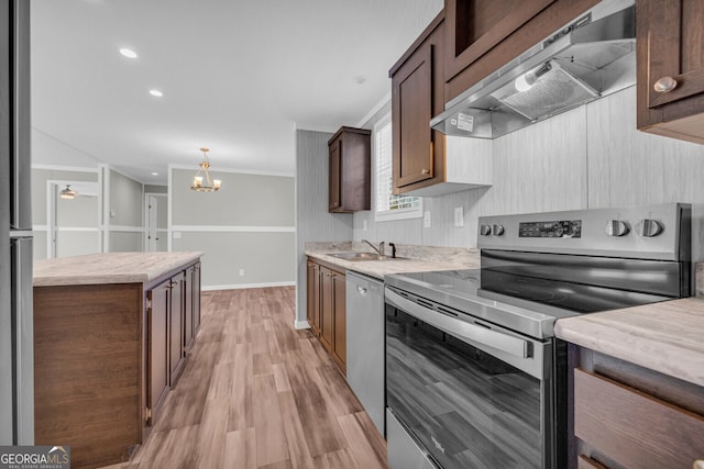 kitchen featuring wall chimney exhaust hood, sink, dishwasher, hanging light fixtures, and stainless steel range with electric cooktop