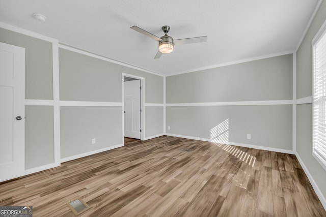 spare room with hardwood / wood-style flooring, ceiling fan, and crown molding