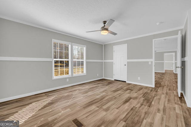 spare room with ceiling fan, light hardwood / wood-style floors, and ornamental molding