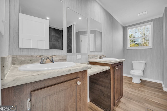 bathroom featuring vanity, hardwood / wood-style flooring, toilet, and crown molding