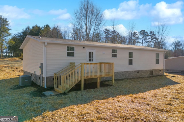 rear view of house featuring a deck, central AC unit, and a lawn