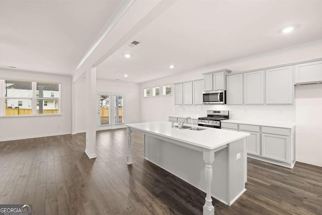 kitchen with stainless steel appliances, a center island with sink, crown molding, dark hardwood / wood-style flooring, and sink