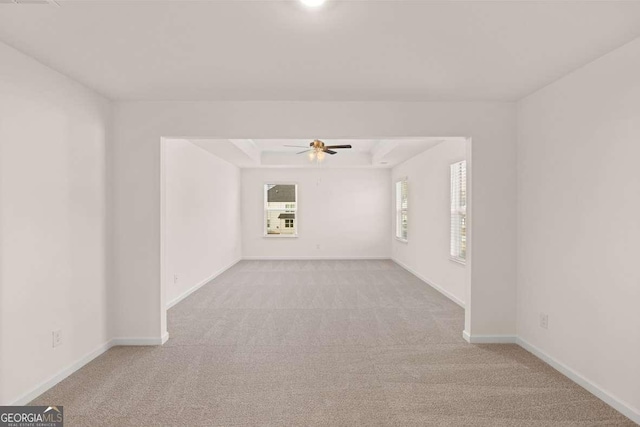 carpeted spare room featuring ceiling fan and a tray ceiling