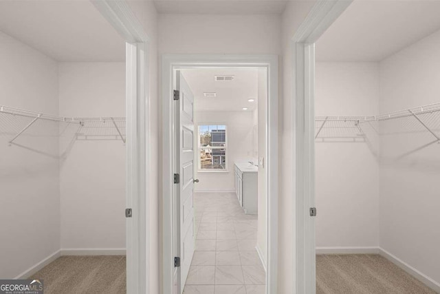 walk in closet featuring light carpet