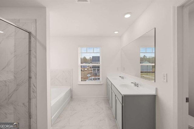 bathroom featuring vanity and independent shower and bath