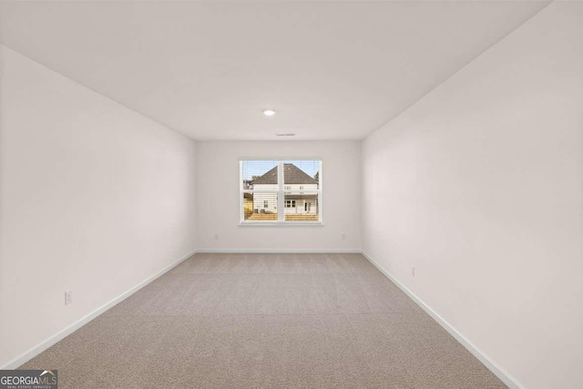 unfurnished room featuring light colored carpet