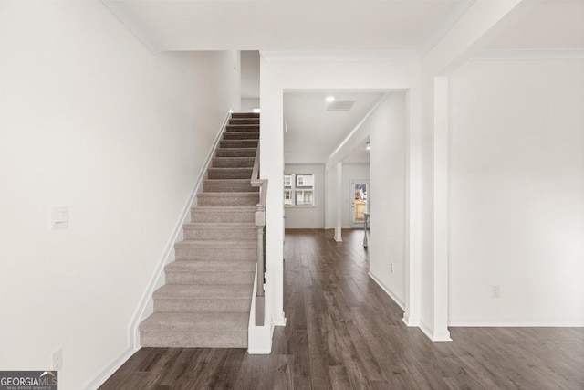 staircase with crown molding and hardwood / wood-style flooring