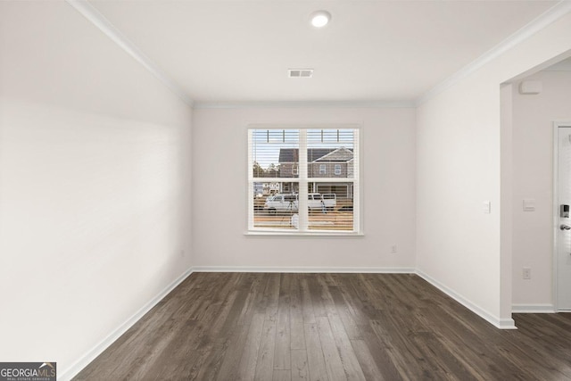 spare room featuring ornamental molding and dark hardwood / wood-style flooring