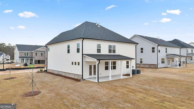 back of house with a lawn, central AC unit, and a patio